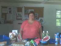 Jeanne stands in front of a massive pile of gifts she brought to us at the shelter